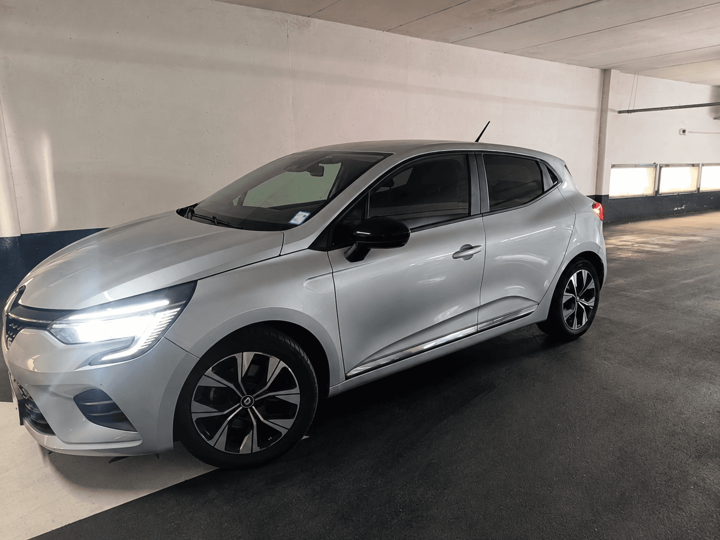 Renault Clio 5 grise, vue avant trois quarts, en parking couvert
